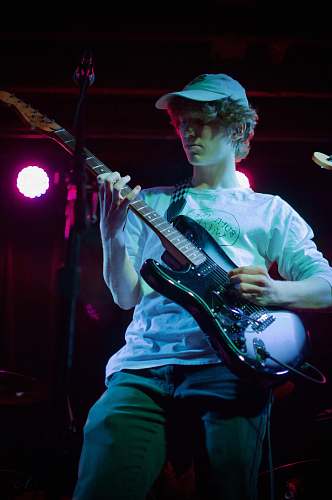 musical instrument man in white dress shirt playing electric guitar guitar